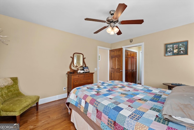 bedroom with light hardwood / wood-style flooring, ceiling fan, and a closet