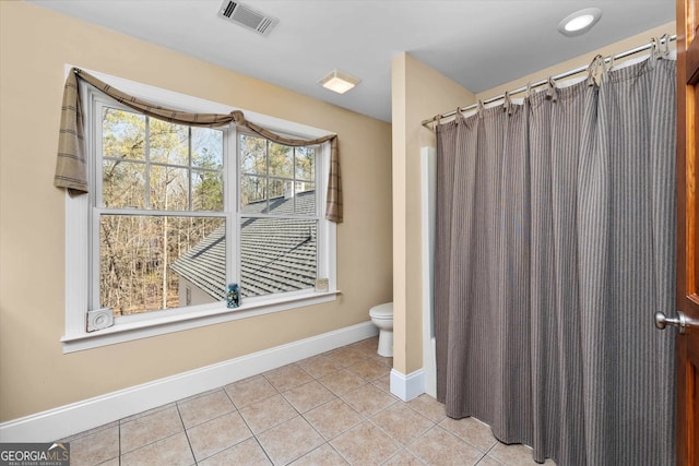 bathroom with shower / bathtub combination with curtain, toilet, and tile flooring