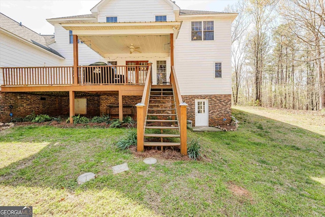 back of property featuring a wooden deck, a lawn, and ceiling fan