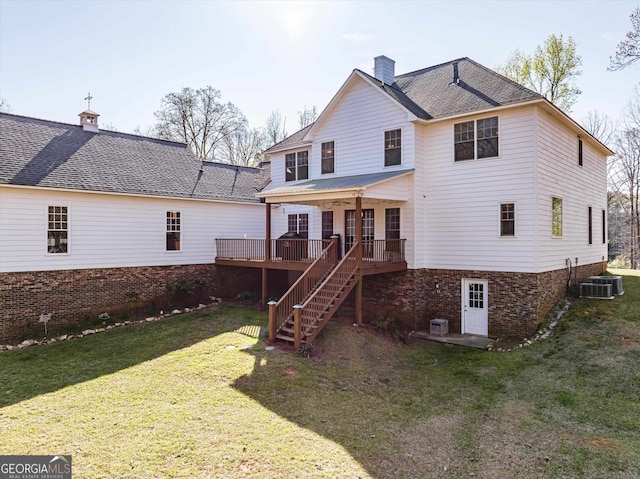 rear view of property with central AC unit, a yard, and a wooden deck