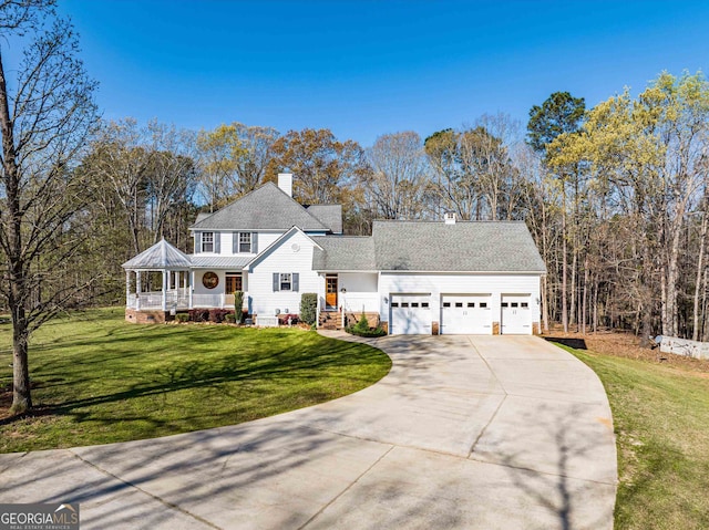 view of front of home featuring a front yard, a garage, and covered porch