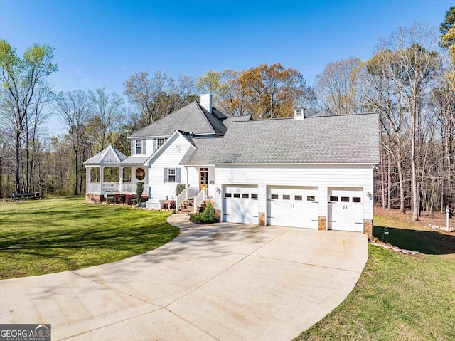 view of front property featuring covered porch, a garage, and a front yard