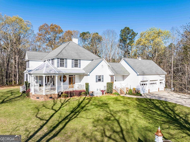 view of front of property with covered porch, a garage, and a front lawn