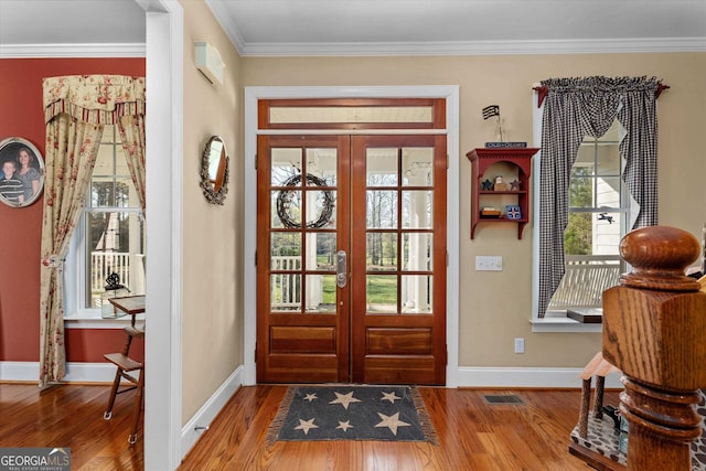 foyer with french doors, crown molding, and dark hardwood / wood-style floors