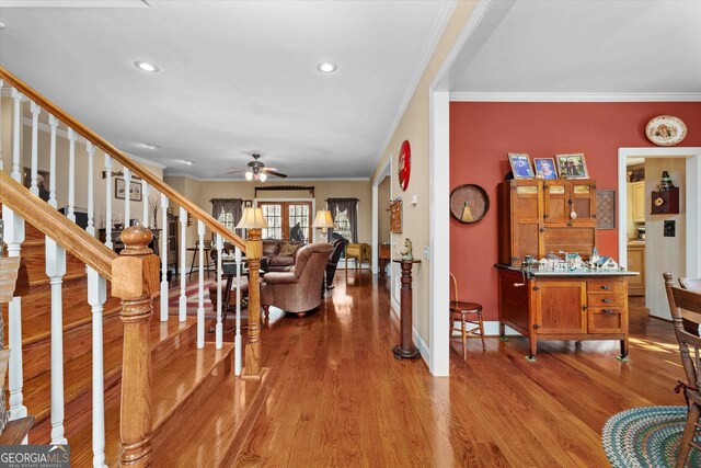 entryway featuring wood-type flooring, ceiling fan, and ornamental molding