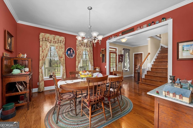 dining room with a notable chandelier, crown molding, and dark hardwood / wood-style floors