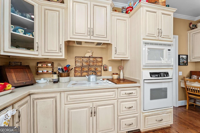 kitchen with cream cabinetry, white appliances, dark wood-type flooring, and crown molding