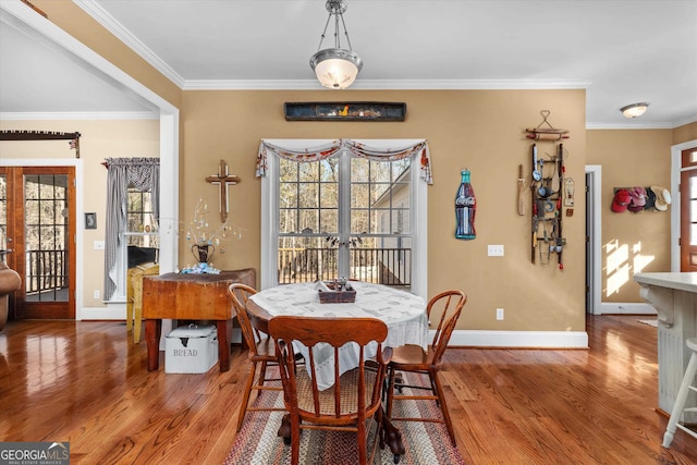 dining area with french doors, light hardwood / wood-style floors, and crown molding