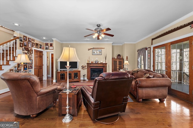 living room with ornamental molding, ceiling fan, and dark wood-type flooring