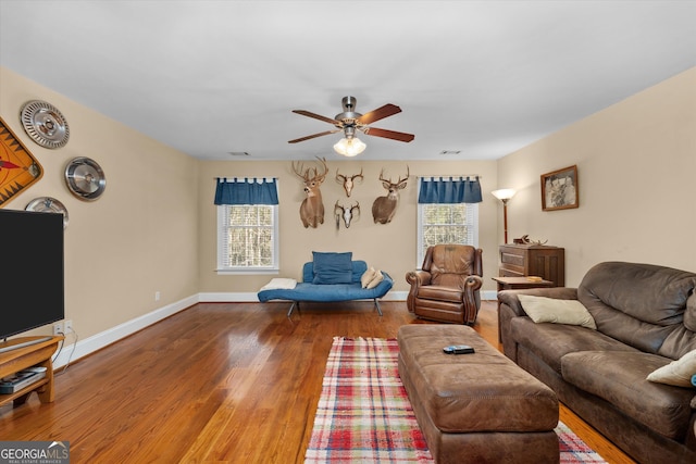 living room featuring plenty of natural light, wood-type flooring, and ceiling fan