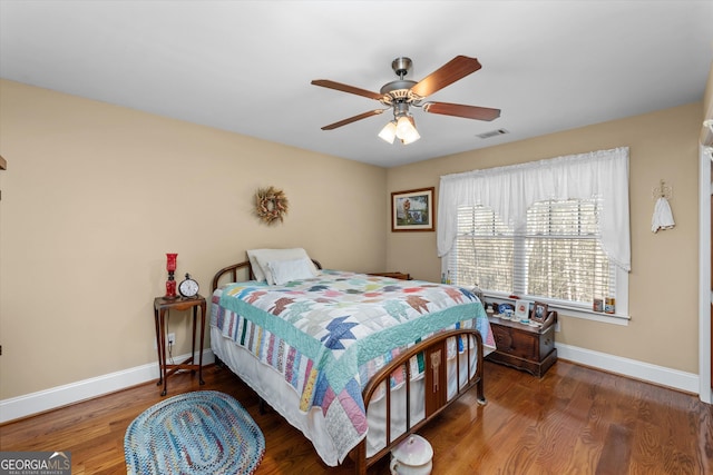 bedroom with dark hardwood / wood-style flooring and ceiling fan