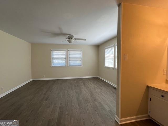 empty room featuring ceiling fan and dark wood-type flooring