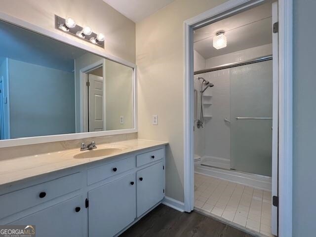 bathroom featuring an enclosed shower, toilet, tile floors, and vanity