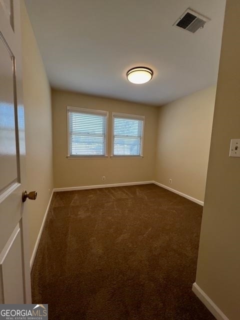 empty room featuring dark carpet