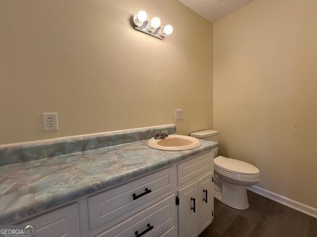 bathroom with hardwood / wood-style floors, toilet, and vanity