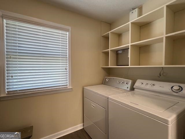 laundry area featuring a textured ceiling, separate washer and dryer, and dark wood-type flooring