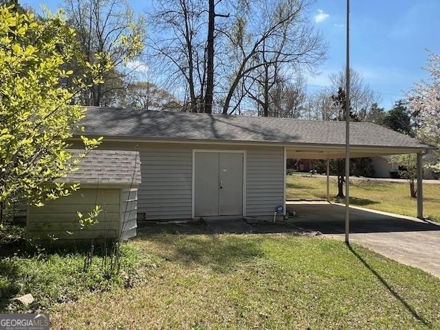 view of outdoor structure featuring a lawn and a carport