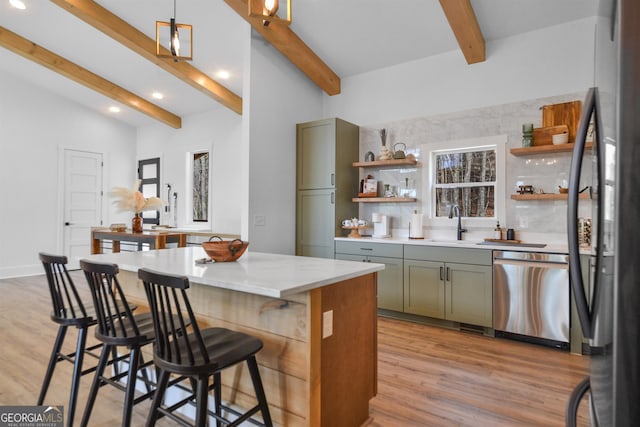 kitchen featuring tasteful backsplash, light hardwood / wood-style floors, stainless steel appliances, and vaulted ceiling with beams