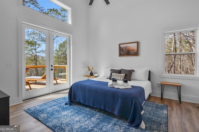 bedroom featuring a high ceiling, ceiling fan, dark hardwood / wood-style floors, and access to exterior