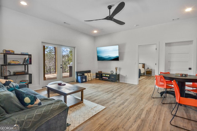 living room with ceiling fan, light hardwood / wood-style flooring, and built in shelves