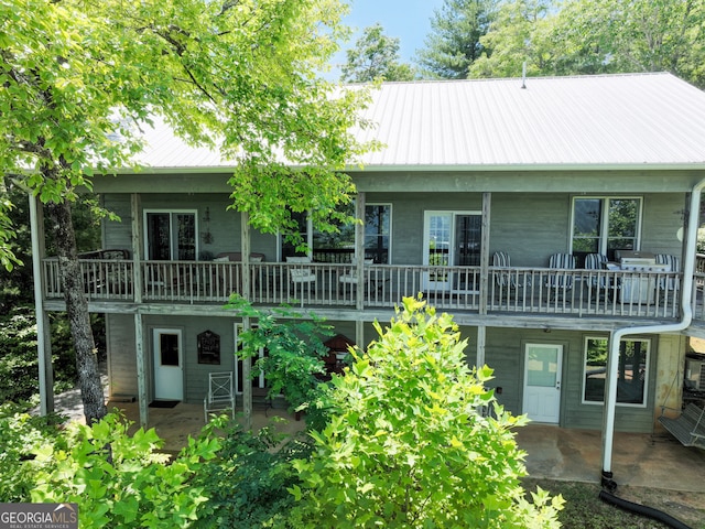 view of front of house featuring a wooden deck and a patio area