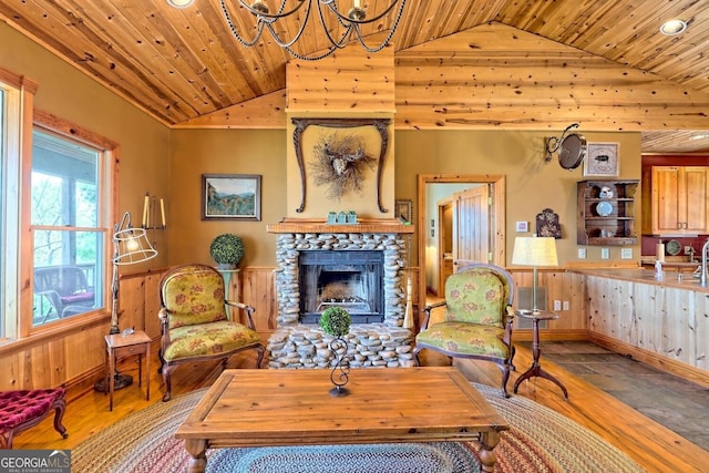 sitting room featuring a stone fireplace, wood ceiling, and hardwood / wood-style flooring