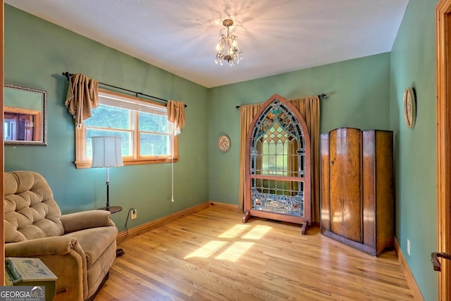 living area with a notable chandelier and light hardwood / wood-style flooring