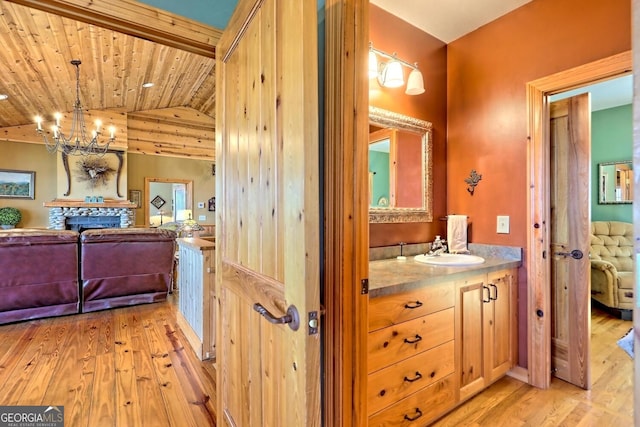 bathroom featuring vanity, wood ceiling, vaulted ceiling, and hardwood / wood-style floors