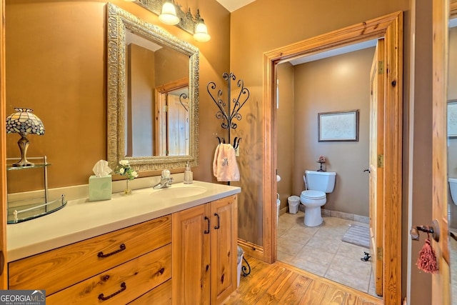 bathroom featuring vanity, toilet, and hardwood / wood-style flooring