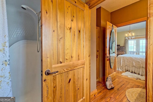 bathroom featuring an inviting chandelier and wood-type flooring