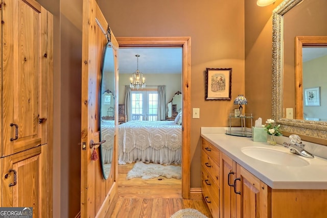 bathroom with vanity, a chandelier, and wood-type flooring