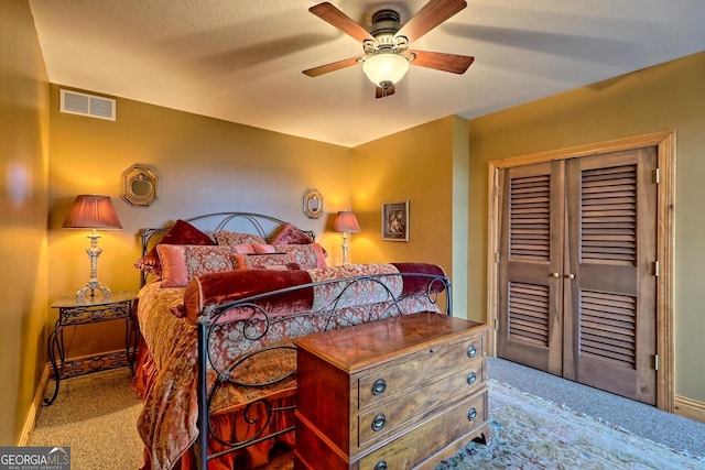 bedroom featuring light carpet, a textured ceiling, a closet, and ceiling fan