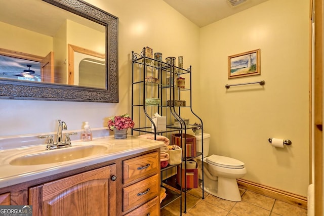 bathroom featuring vanity, toilet, tile patterned flooring, and ceiling fan