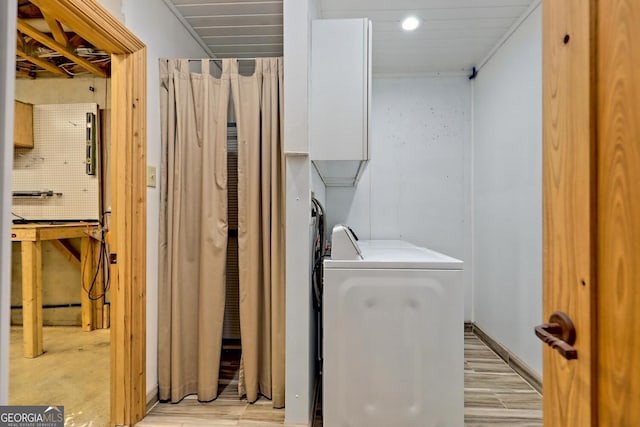 washroom with washer / dryer, light hardwood / wood-style floors, and a workshop area