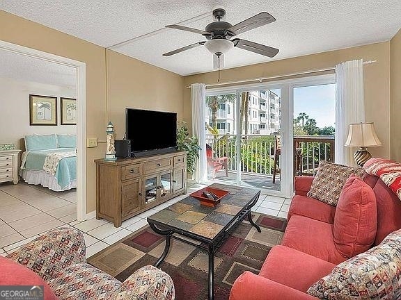 tiled living room featuring a textured ceiling and ceiling fan