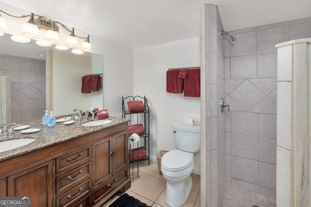 bathroom featuring toilet, double vanity, tile flooring, and tiled shower