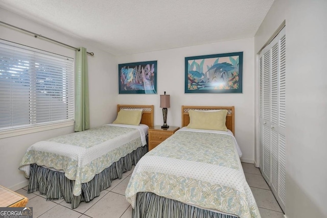 tiled bedroom featuring a textured ceiling and a closet