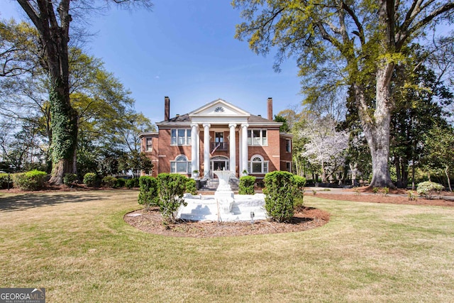 neoclassical home featuring a front yard