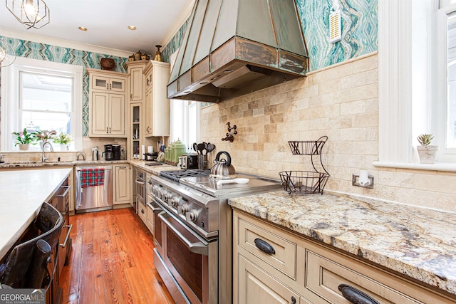 kitchen with appliances with stainless steel finishes, backsplash, a wealth of natural light, and custom range hood