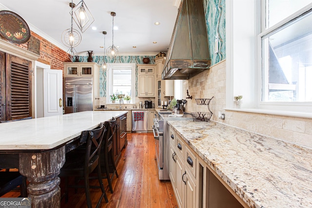 kitchen featuring a center island, a kitchen bar, custom exhaust hood, premium appliances, and crown molding