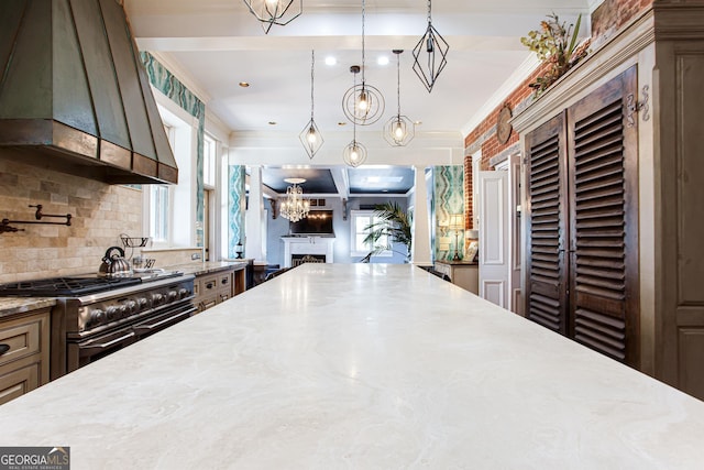 kitchen with tasteful backsplash, light stone counters, custom exhaust hood, decorative light fixtures, and double oven range