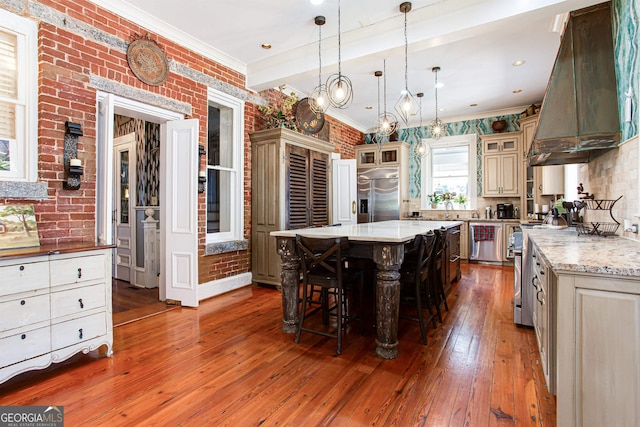 kitchen with custom range hood, premium appliances, a center island, pendant lighting, and dark hardwood / wood-style floors