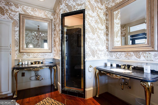 bathroom with a shower with door, crown molding, sink, and hardwood / wood-style floors