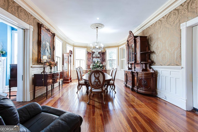 dining area featuring crown molding, dark hardwood / wood-style floors, and a chandelier