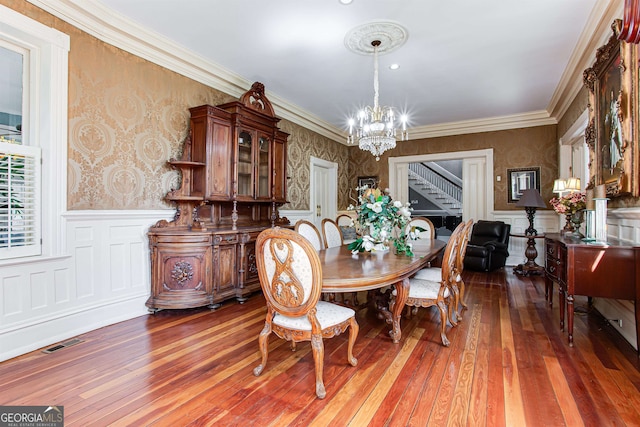 dining room featuring crown molding, dark hardwood / wood-style flooring, and an inviting chandelier