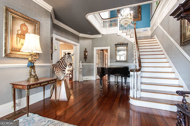 foyer with ornamental molding, a chandelier, and dark wood-type flooring