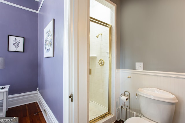 bathroom featuring toilet, hardwood / wood-style floors, and a shower with shower door