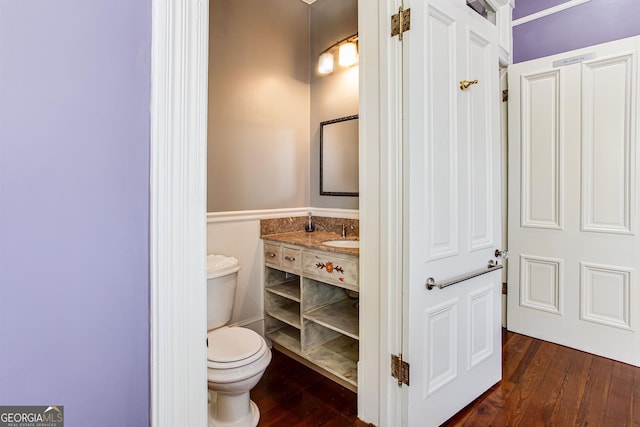 bathroom featuring toilet, vanity, and wood-type flooring