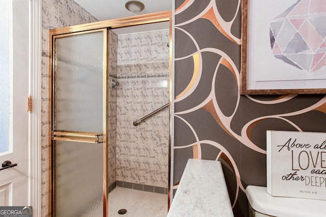 bathroom featuring a shower with shower door and tile flooring