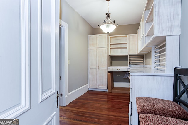 kitchen with built in desk, pendant lighting, and dark hardwood / wood-style floors